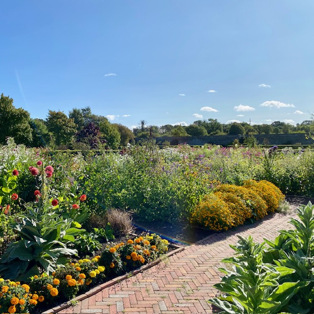 Potager garden with brick path and mixed ornamental planting.