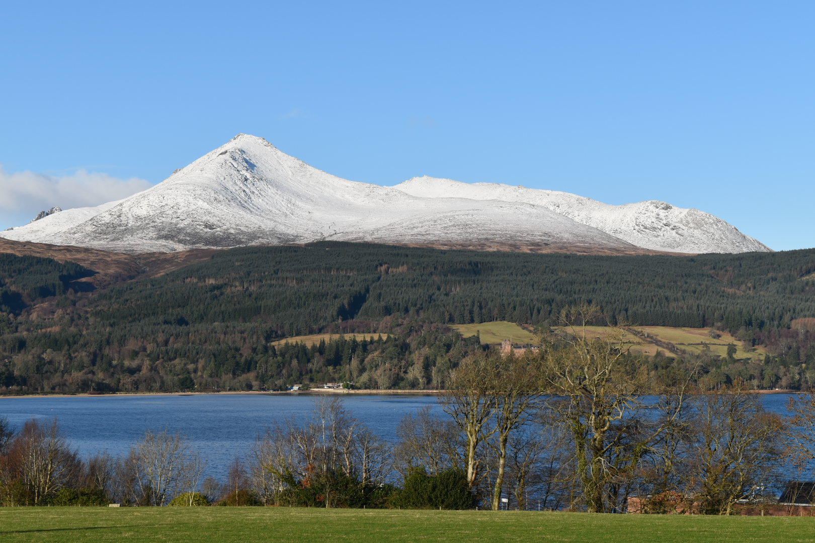 Isle of Arran with blue sky and white fluffy clouds.