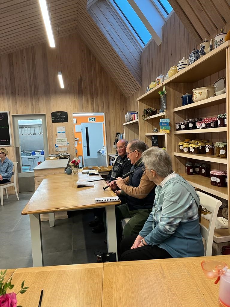 A group of people sitting at a table looking at someone telling a story.