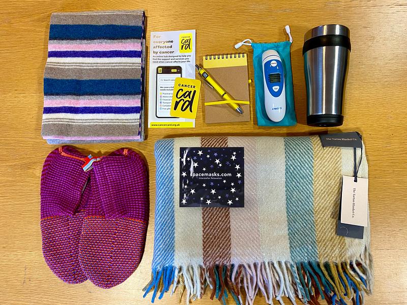 Free gifts for newly diagnosed cancer patients - digital thermometer, wool blanket, travel mug, slipper socks, notepad and pen, cosy scarf