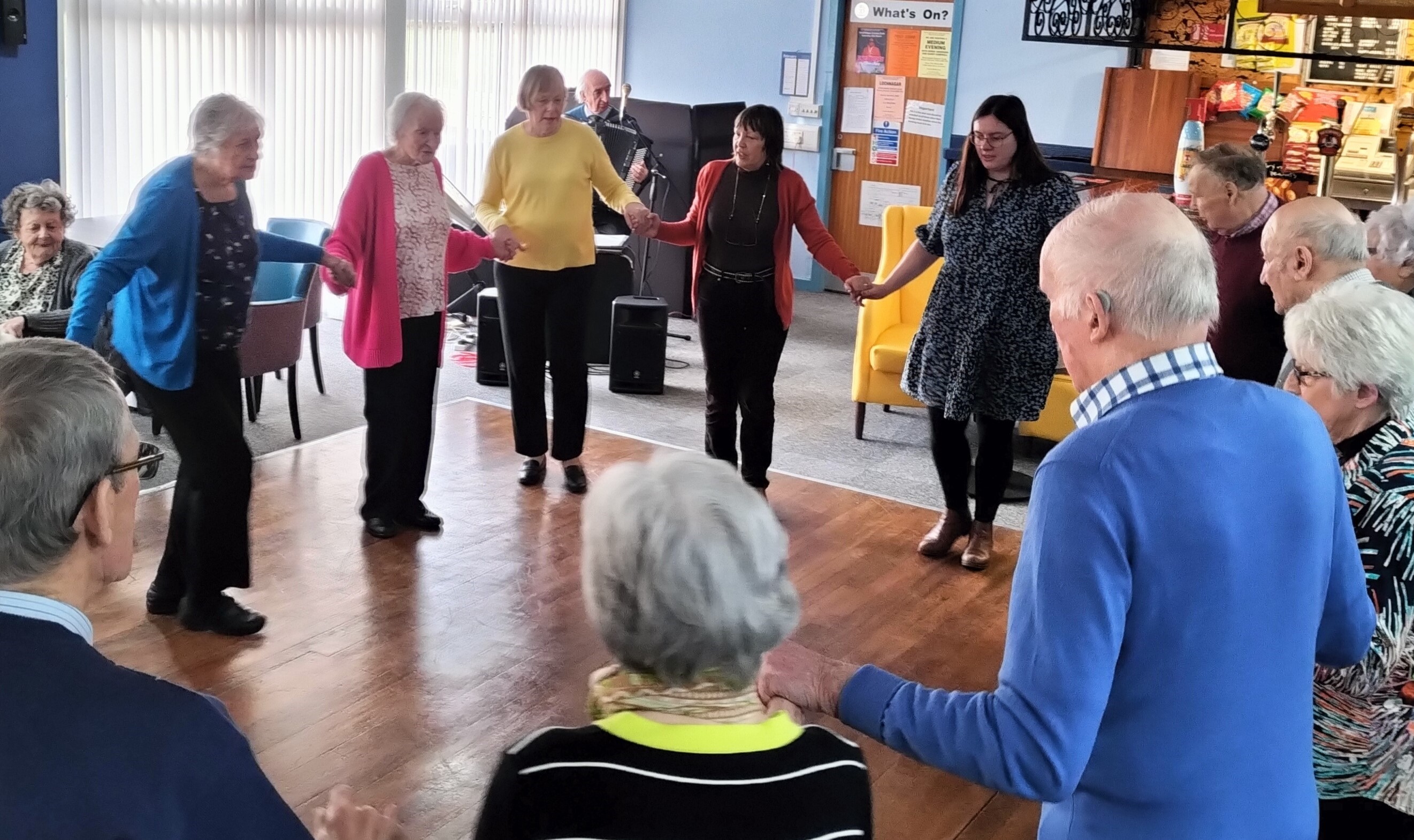 Group of dancers, holding hands in a circle doing the friendship waltz.