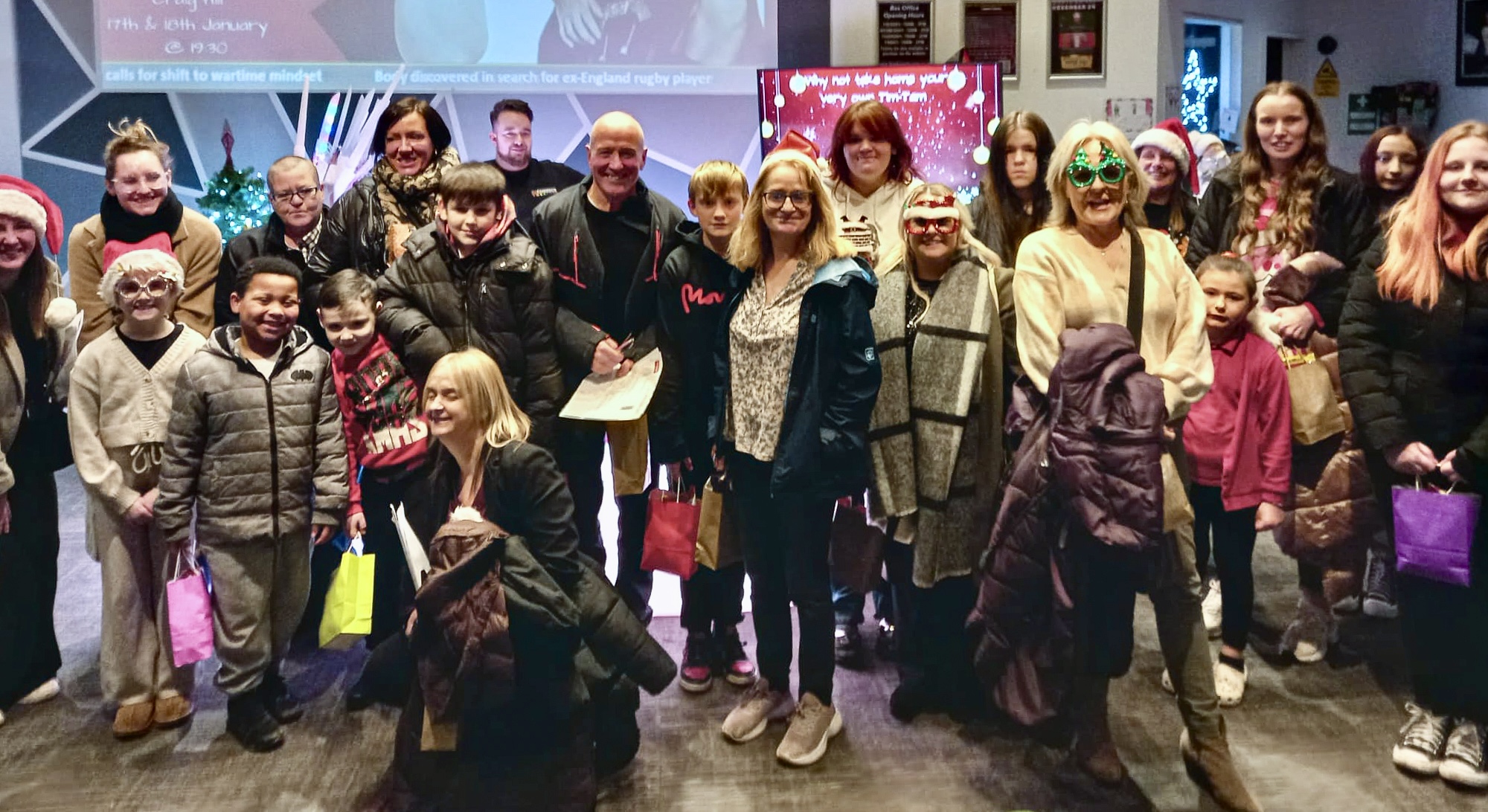 A large group of children and adults smiling at the camera dressed in outdoor costumes.