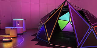 Image shows a dome with ambient purple lighting outside and projected colours inside.